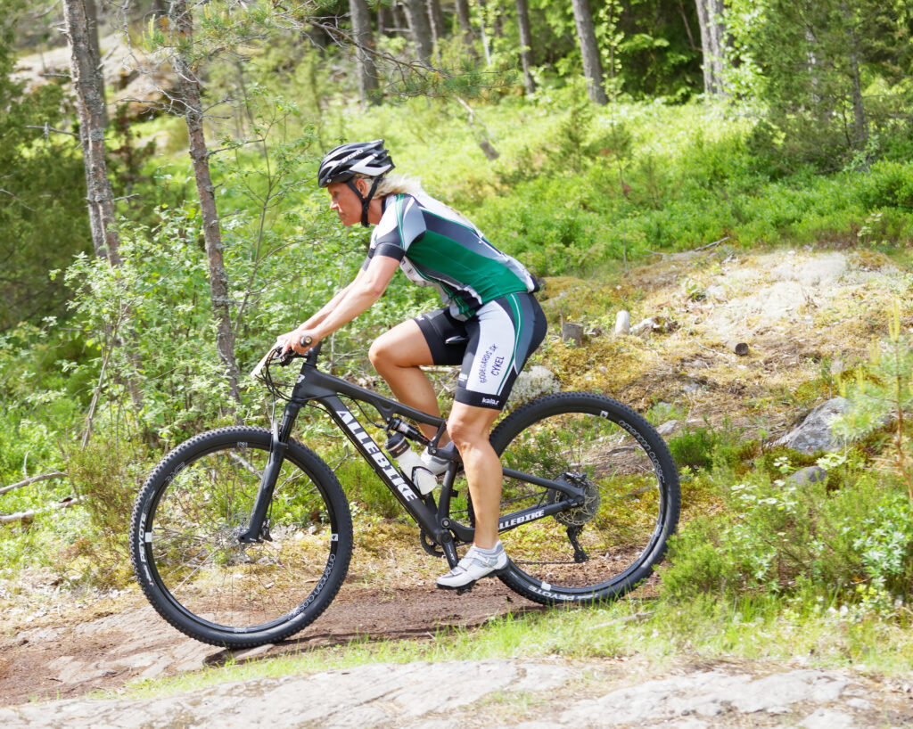 kvinna på mountainbike i skogen